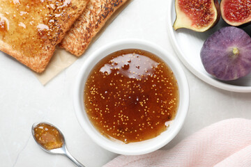 Flat lay composition with delicious fig jam on light grey table