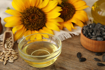 Sunflower oil and seeds on wooden table, closeup