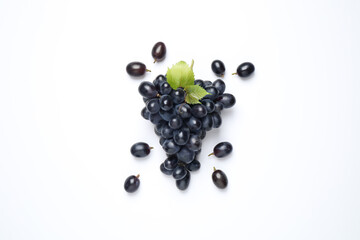 Bunch of dark blue grapes with green leaves on white background, top view