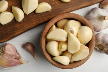 Fresh organic garlic on white wooden table, flat lay