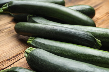 Green ripe zucchinis on wooden table, closeup