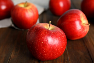 Ripe red apples on wooden table, closeup