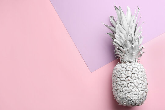 White pineapple on color background, top view with space for text. Creative concept