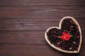 Dry hibiscus tea and flower on wooden table, top view. Space for text