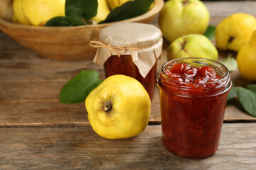 Delicious quince jam and fruits on wooden table, closeup