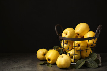 Fresh ripe organic quinces with leaves on grey table