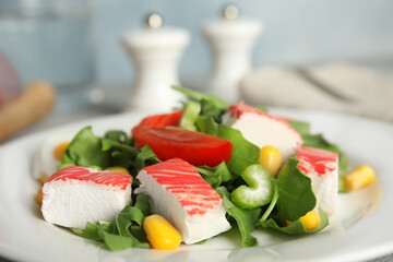 Delicious crab stick salad on white plate, closeup