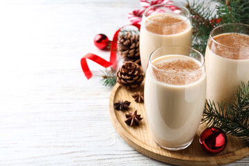 Delicious Christmas cocktail with liqueur on white wooden table. Space for text