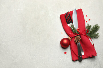 Cutlery set and Christmas decor on light grey table, flat lay. Space for text