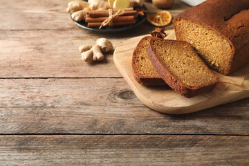 Fresh sliced gingerbread cake on wooden table, space for text