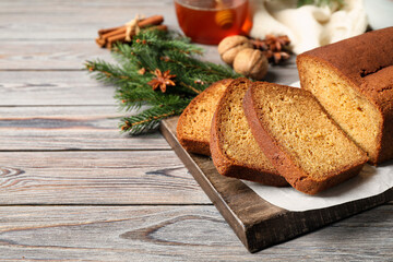 Fresh sliced gingerbread cake on wooden table, space for text