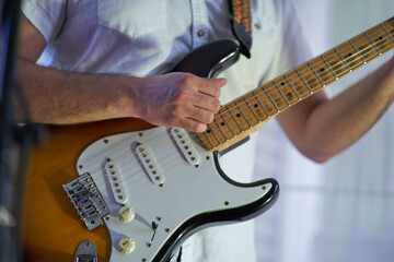 closeup of musician strumming his electric guitar