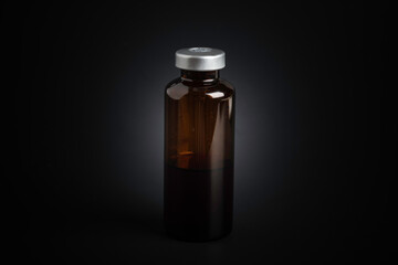 Macro Image Of Amber Vaccine Vial In Black Background
