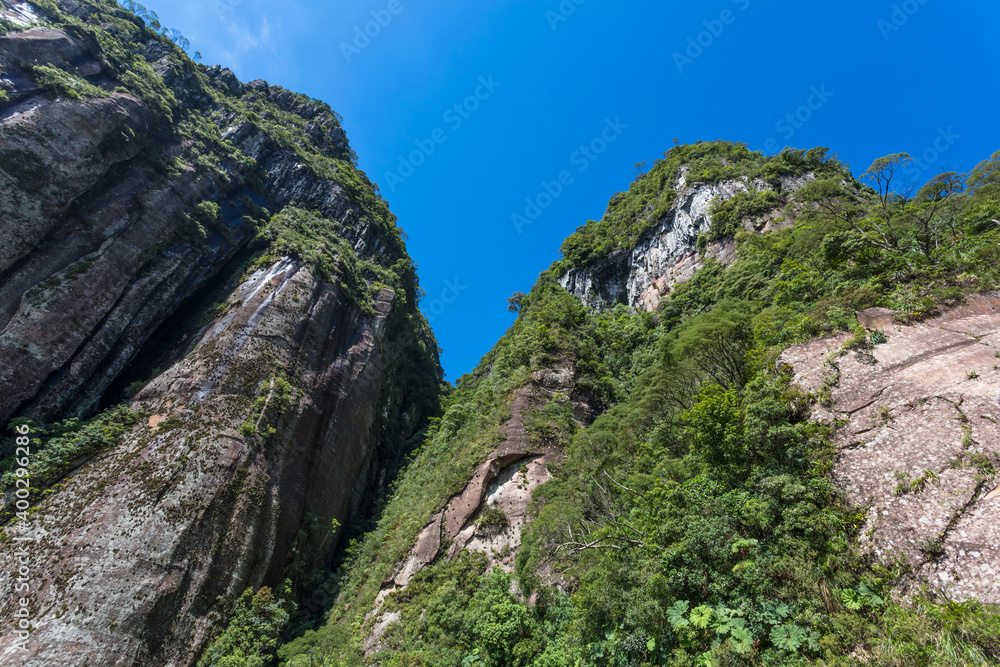 Canvas Prints Montanha de rocha com floresta e céu azul.