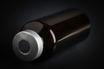 Macro Image Of Amber Vaccine Vial In Black Background