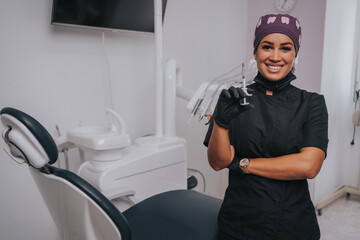 Young blond Caucasian female opening her mouth while African-American ethnic dentist in white latex gloves check condition of her teeth focus on dentist