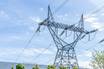 One Electric transmission tower at nuclear generating station with blue sky in background.