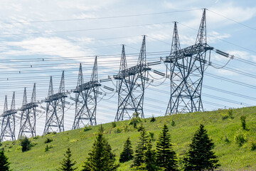 A row of Electric transmission towers at nuclear generating station with blue sky in background. 