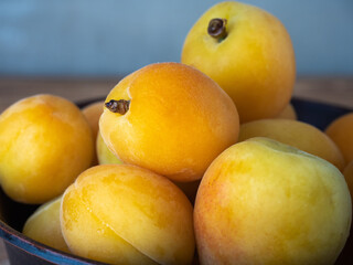 Yellow apricots close-up in a deep plate