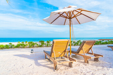 Umbrella and deck chair around outdoor swimming pool in hotel resort