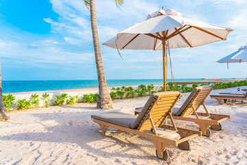 Umbrella and deck chair around outdoor swimming pool in hotel resort