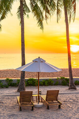 Umbrella and deck chair on tropical beach sea ocean at sunset or sunrise time