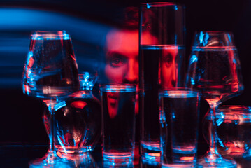 psychedelic surreal portrait of a man through glasses of water with blur