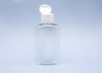 Transparent empty cosmetic bottles and jars on a blue background.