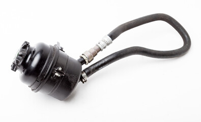 Car spare part - used plastic black tank of power steering oil fluid on a white isolated background...