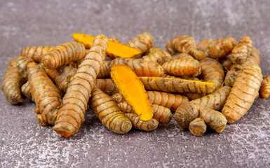 Fresh turmeric root on grey slate background.