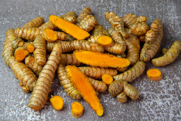 Fresh turmeric root on grey slate background.