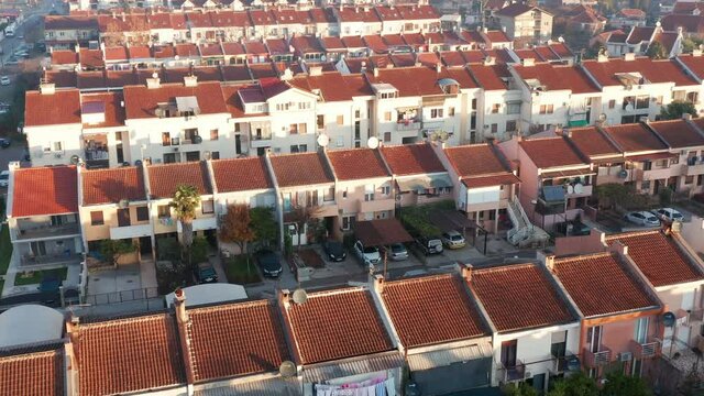 Rows of terrace houses in a mill town. Townhouses with red roofs in a company village or monotown in Europe. Housing project in suburban neighborhood. Aerial drone view.