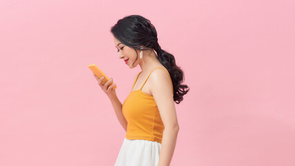 Young woman doctor holding her smartphone while smiling into the camera
