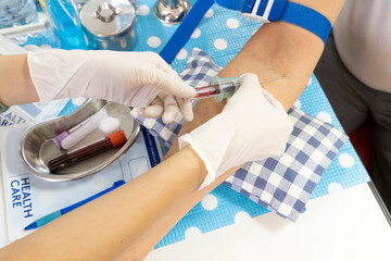 Nurse taking blood sample from the patient's arm vein for blood test.