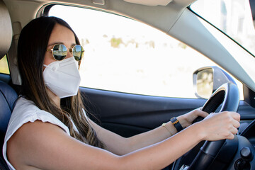 Joven mujer  latina manejando  una camioneta y usando mascarilla