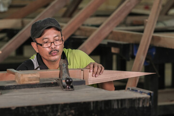 Carpenter making Tunjuk Langit or one of the roof structures. Hip Roof