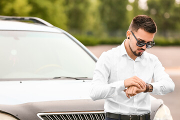 Handsome man near modern car