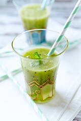 Green smoothie topped with chia seeds on bright wooden background. Close up. 