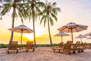 Umbrella and deck chair on tropical beach sea ocean at sunset or sunrise time