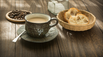A cup of coffee and  breads on the wooden table.