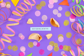 Motivational New Year celebration concept with open fortune cookie and text 'Next year will be great' on colorful background with paper streamers and confetti