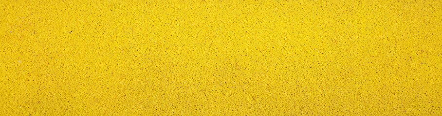 Yellow foam roller brush, close up. Used for home renovation and professional painters, mainly for smooth surfaces. Small circle pattern and rough grunge texture.