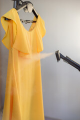 The yellow dress is ironed with a steam generator