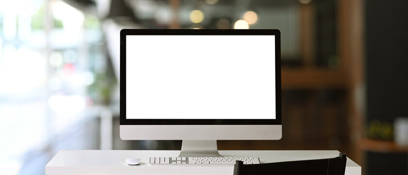 Front view of a computer with blank on white table at contemporary office.