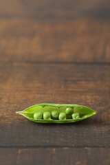 Fresh green peas isolated on wooden table