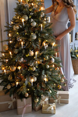Pregnant woman dressing up a Christmas tree. New Year. background, space for your text.