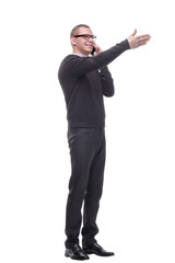 Young adult man talking on the phone pointing with finger to the camera and to you
