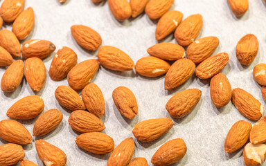almonds top view closeup on pale white paper background