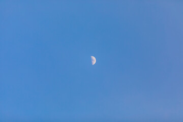  half moon in the blue sky at the day time.