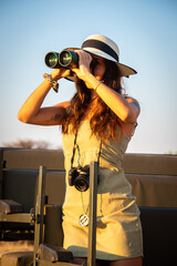 Close-up of brunette kneeling looking through binoculars